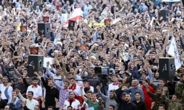 People in a crowd raise their fists in salute